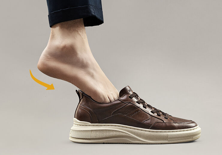 Sapato masculino marrom com pé usando, em fundo neutro