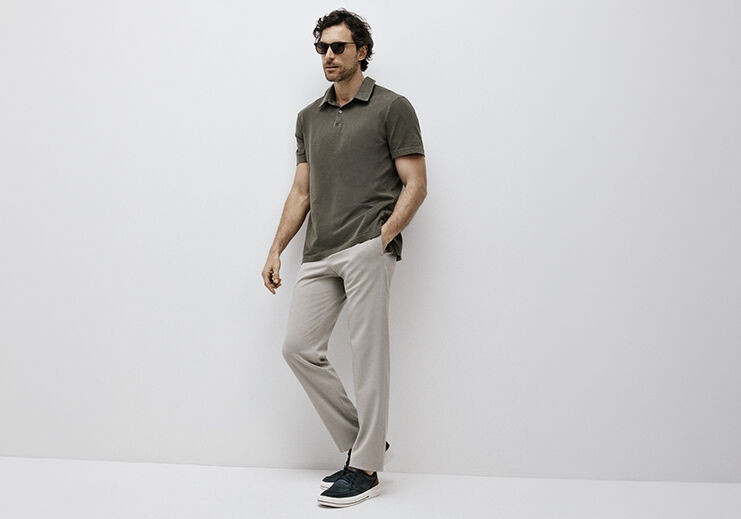 Homem com blusa polo e calça clara posando para foto.