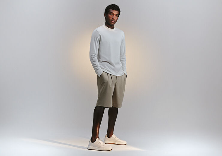 Homem em camiseta e shorts claros com tênis