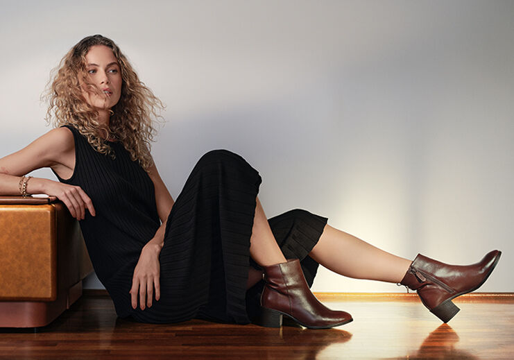 Mulher elegante usando vestido preto e botas marrons