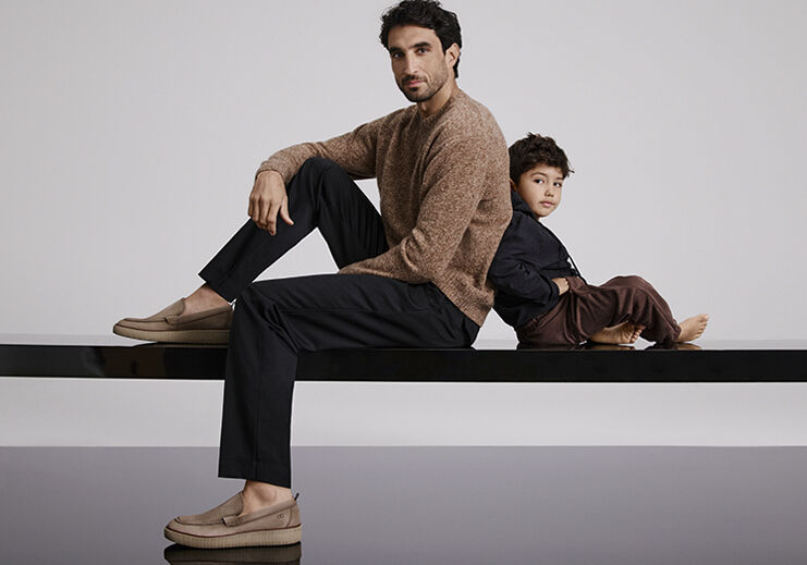 Pai e filho posando em um cenário moderno e elegante.