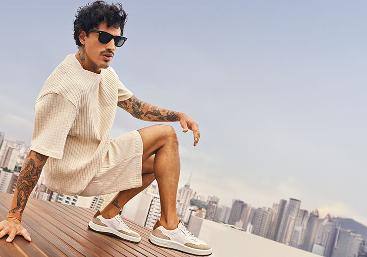 Homem estiloso em roupa casual com cenários urbanos ao fundo