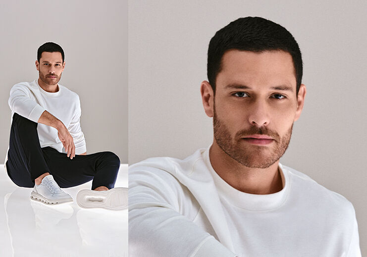Modelo masculino usando tênis branco em fundo neutro